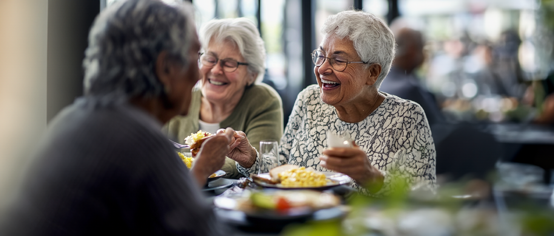 Some elderly women dine together, enjoying one another's company