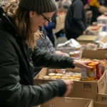 A woman sorts through the bins of a busy community food bank, thanks to TEFAP.